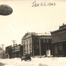 dated Jan. 25, 1943 looking SW toward the library, 121 N Main St.; the list of boys from the area who had gone off to fight in World War II stands on the lawn, the display was painted by Ralph Pulver